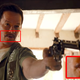 Mark Wahlberg stands at the threshold of a doorway brandishing a revolver and a thin mustache.